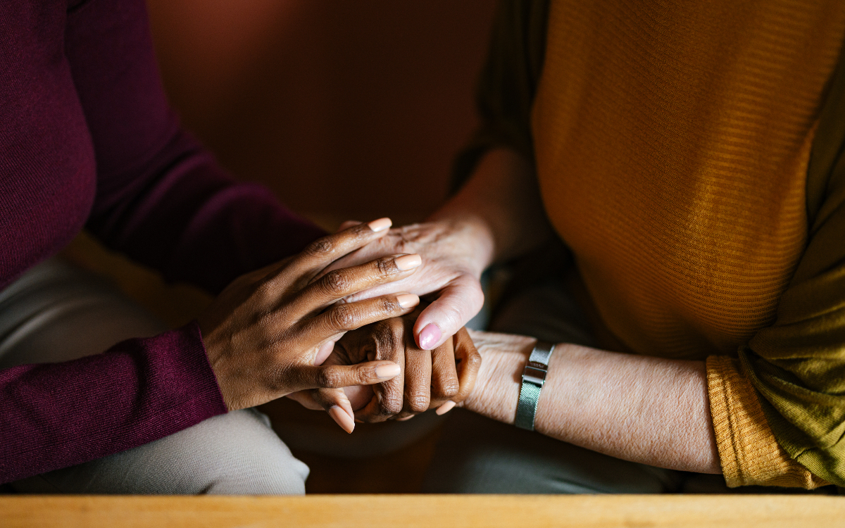 Deux femmes se tenant les mains.