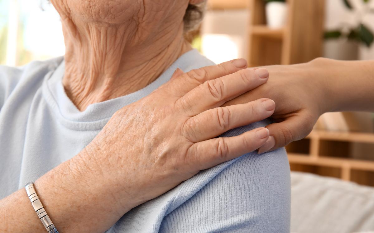 Personne âgée avec main sur son épaule