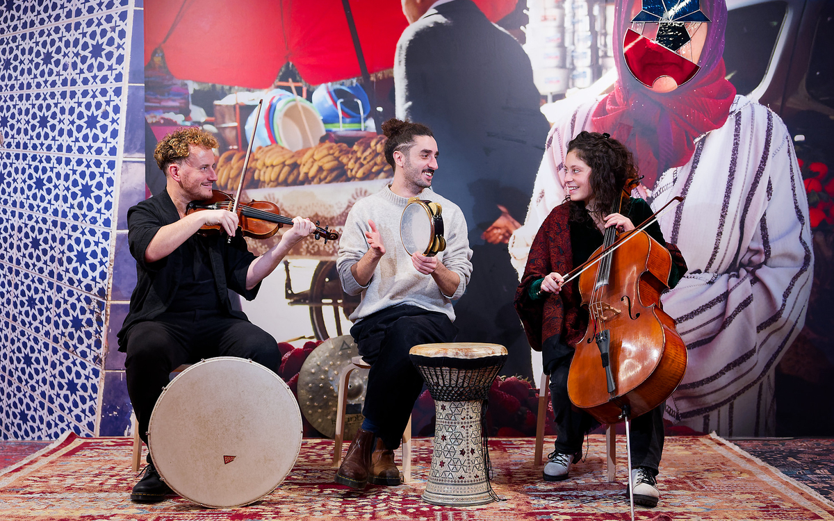 Trio de musiciens devant un mur d'expo