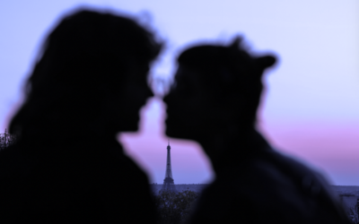 Silhouette floue d'amoureux en premier plan avec la tour Eiffel en arrière plan.