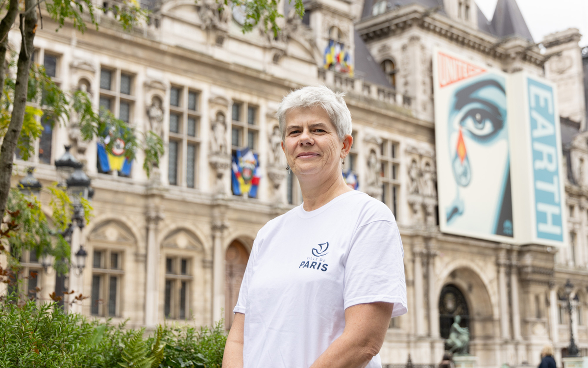 Nathalie Coude en tenue de bénévole devant l'Hôtel de Ville 