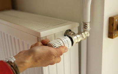 Une personne baisse le chauffage dans un logement