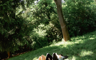 Deux personnes se reposent dans l'herbe dans le parc des buttes chaumont.