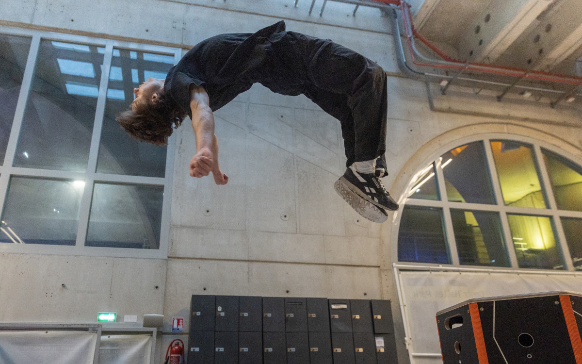 Une personne en plein saut dans la salle de Parkour de Suzanne Berlioux (Paris Centre).