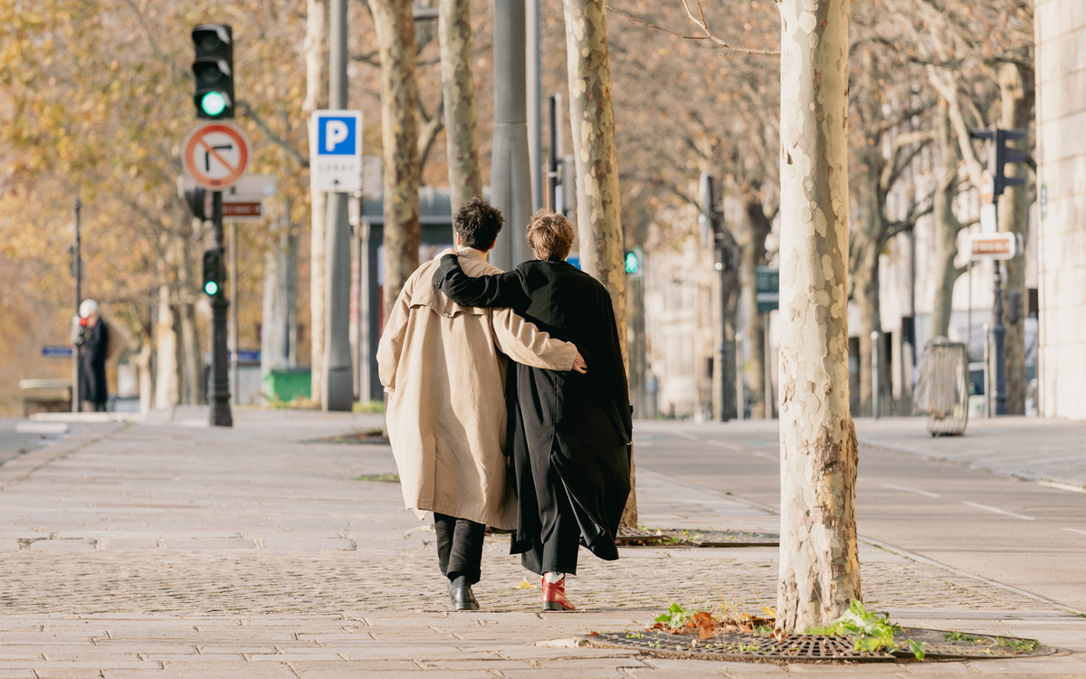 Deux personnes se promènent bras dessus, bras dessous.