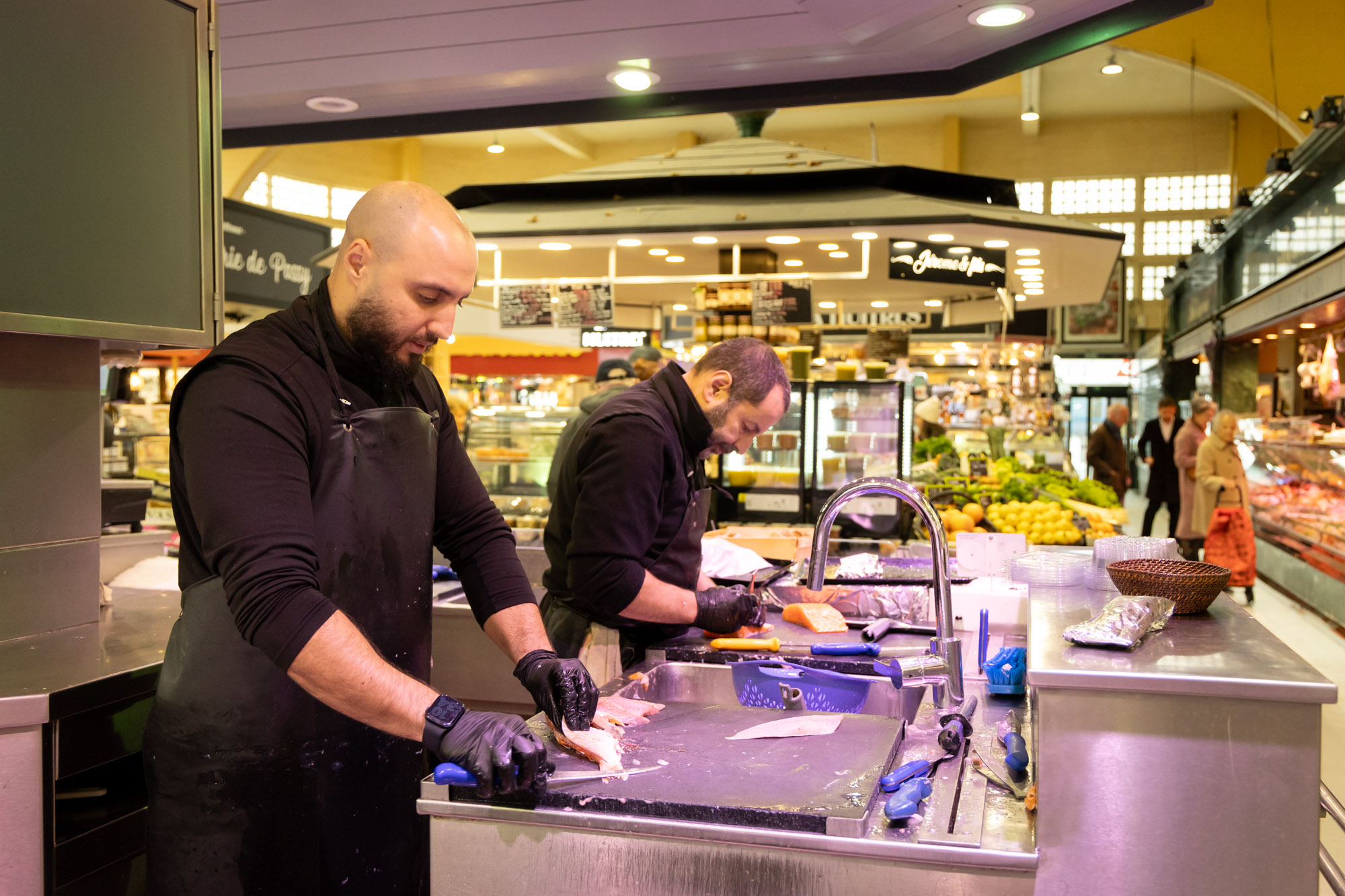 deux hommes découpent du poisson