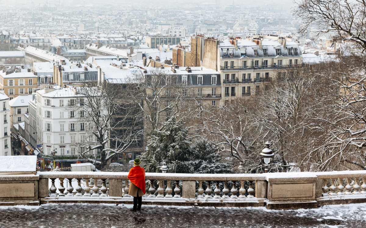 Une personne admire la neige sur Paris depuis la butte Montmartre.