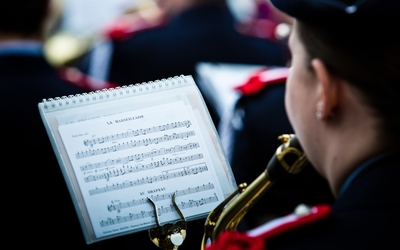 Une femme joue dans un orchestre. En face d'elle on y voit sa partition avec pour titre "La Marseillaise"