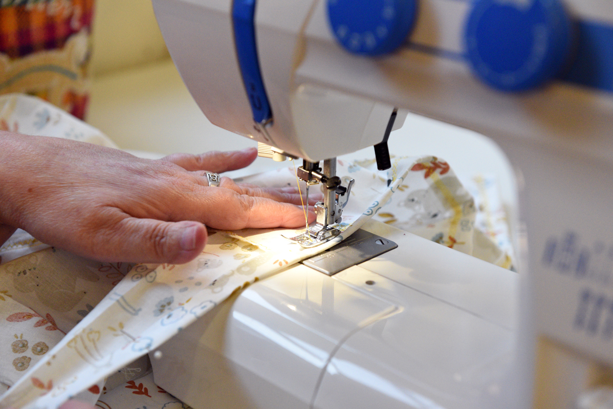 Une couturière coud à sa machine dans l'atelier de couture de la DFPE dans la salle de formation couture qui est située dans les locaux de la crèche municipale des Franc-Bourgeois au 22 rue des Franc-Bourgeois.