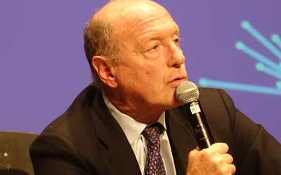 Photographie de Renaud Girard tenant un micro.