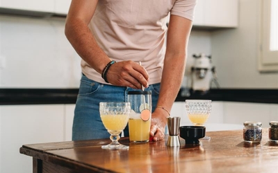un homme qui prépare un cocktail jaune
