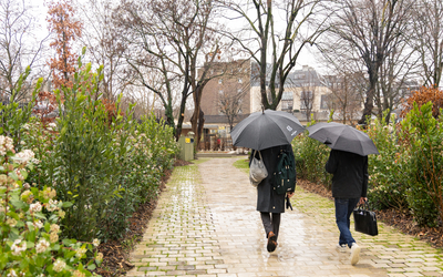 Deux personnes se promènent sous la pluie dans le jardin du Val de Grâce