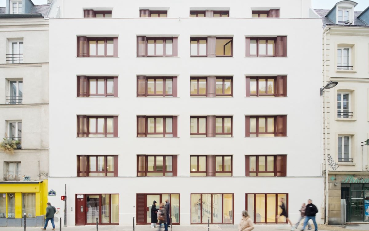 Façade de la résidence donant sur une rue avec des passants.