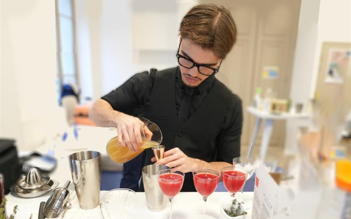 un jeune homme qui prépare un cocktail