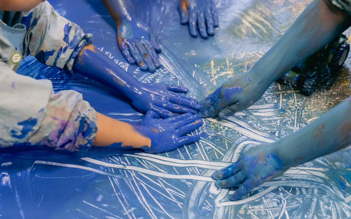 Des mains d'enfants dans la peinture bleue au Jardin d'enfant pédagogique Felix Terrier, 20e