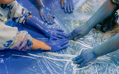 Des mains d'enfants dans la peinture bleue au Jardin d'enfant pédagogique Felix Terrier, 20e