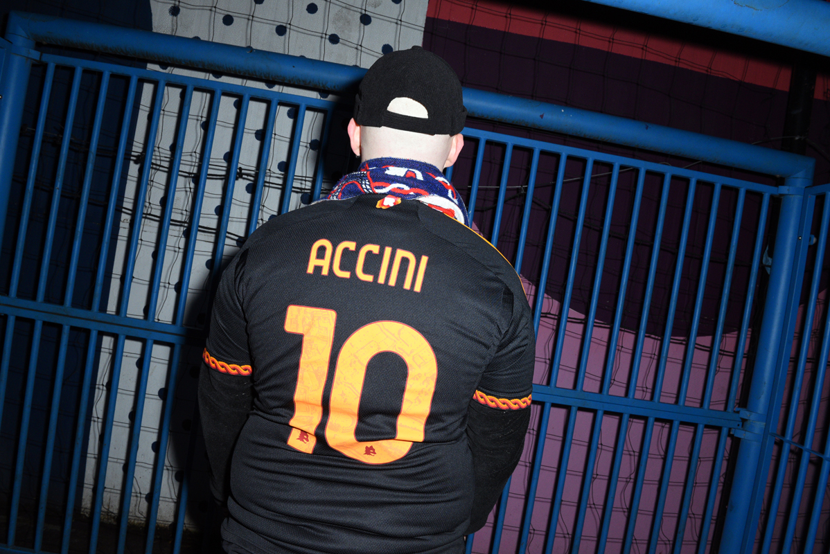 Alessio Bartoccini, supporter du PSG et de l'AS Roma. nous montre le dos de son maillot de foot à son nom. 