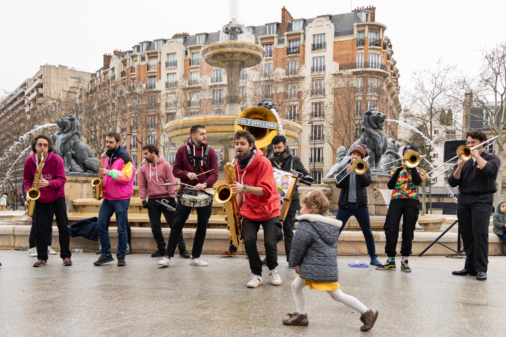 Une fanfare jouant devant une fontaine