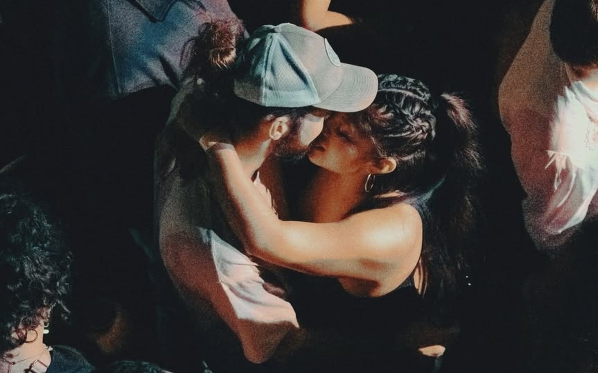 Un couple s'embrasse au milieu d'une foule dans un club