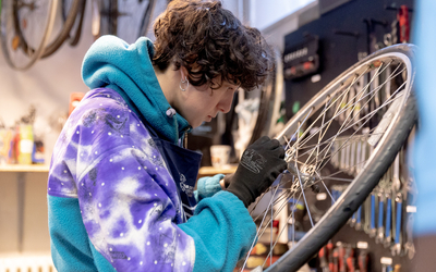 jeune femme réparant une roue de vélo