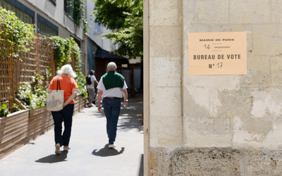 deux électeurs·trices entrent dans un bureau de vote parisien 
