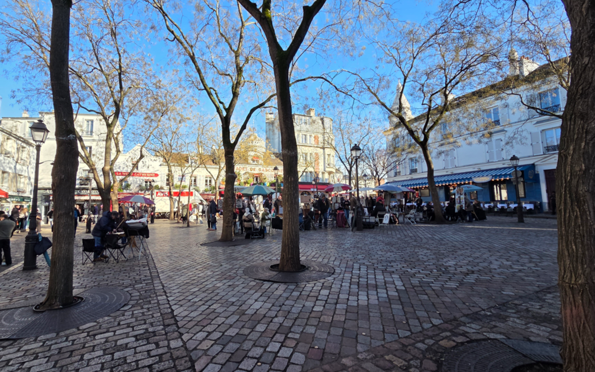 Vue de la place du Tertre en hiver avec un ciel bleu du matin et installation des artistes