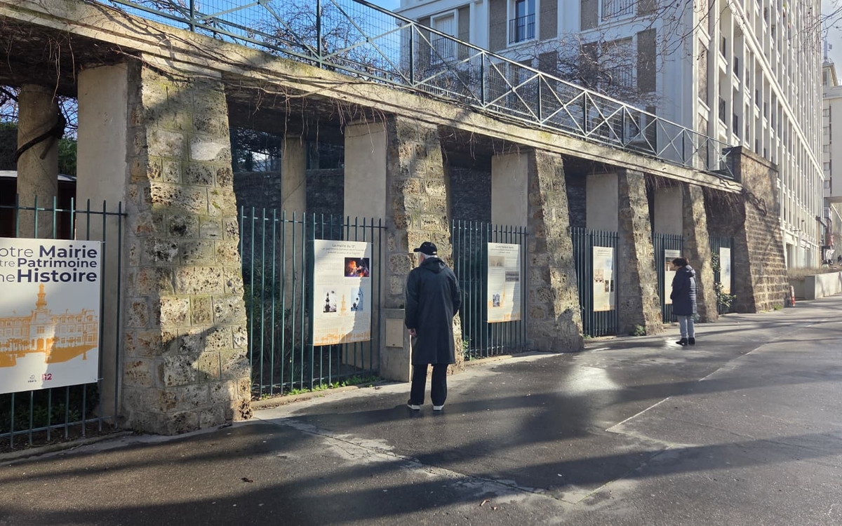 Des panneaux d'exposition consacrée à l'histoire patrimoniale de la mairie du 12e sur les grilles d'un parc 