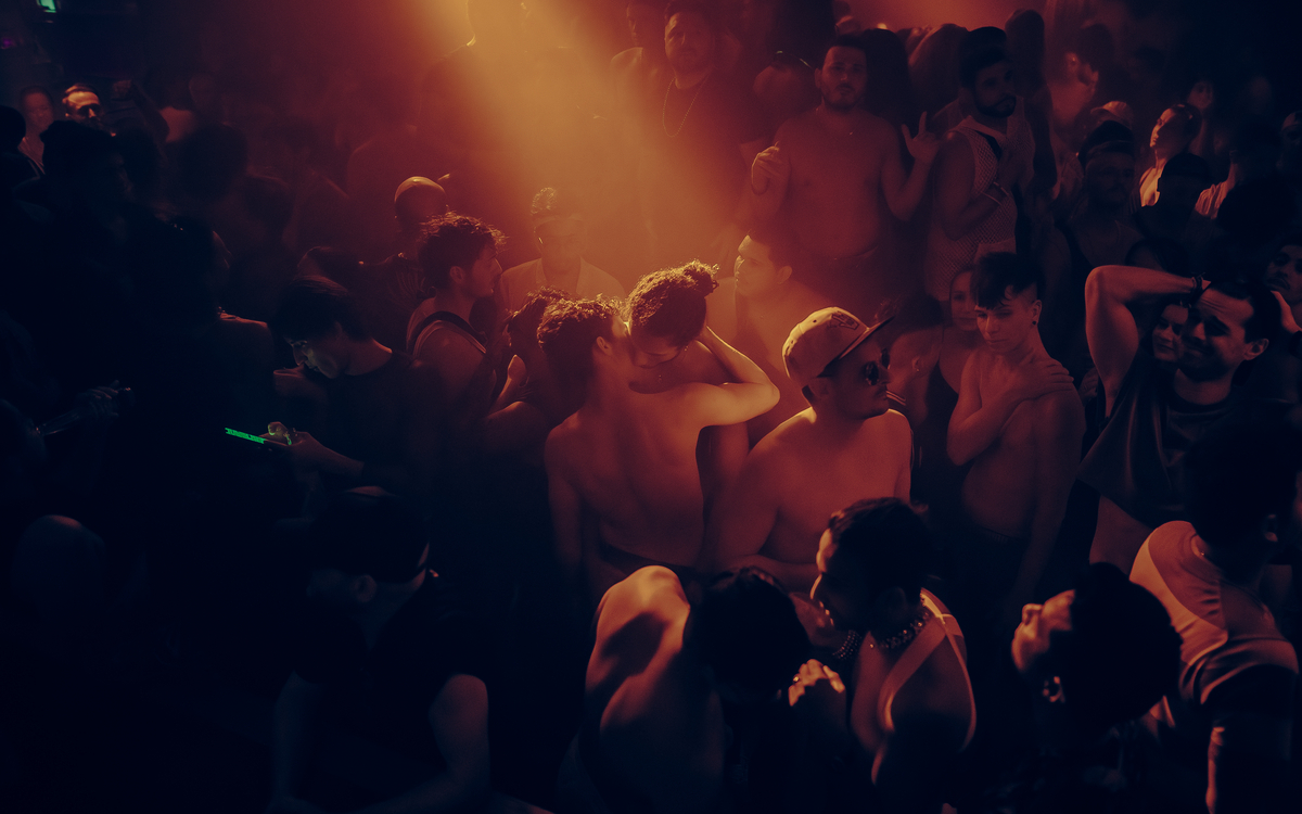 Un couple s'embrasse au milieu d'une foule dans un club