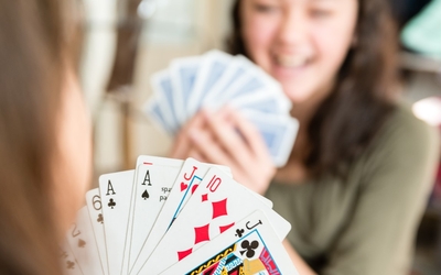 Deux jeunes jouant aux cartes. Nous pouvons voir les cartes d'un des deux joueurs.
