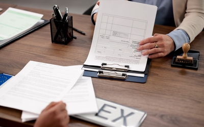 Une personne traite un dossier sur une table avec un agent d'une mairie