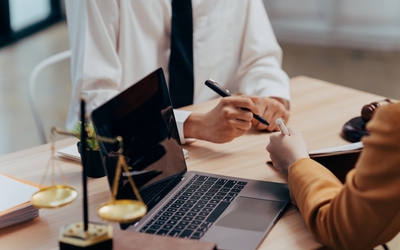 Photo montrant un accord juridique entre deux personnes. Nous pouvons voir que des papiers sont en train d'être signés
