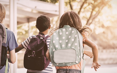 Enfants avec des sacs a dos arrivent à l'école