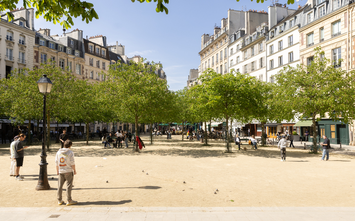Place Dauphine, arborée avec des promeneurs et des joueurs de pétanque.