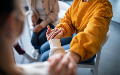 Personnes se tenant les mains en thérapie de groupe.