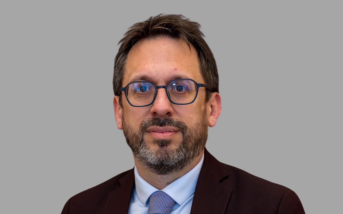 homme à lunettes sur fond gris