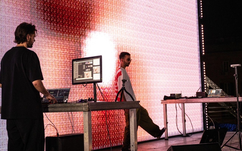 Deux hommes sur scène ave des ordinateurs et du matériel technique