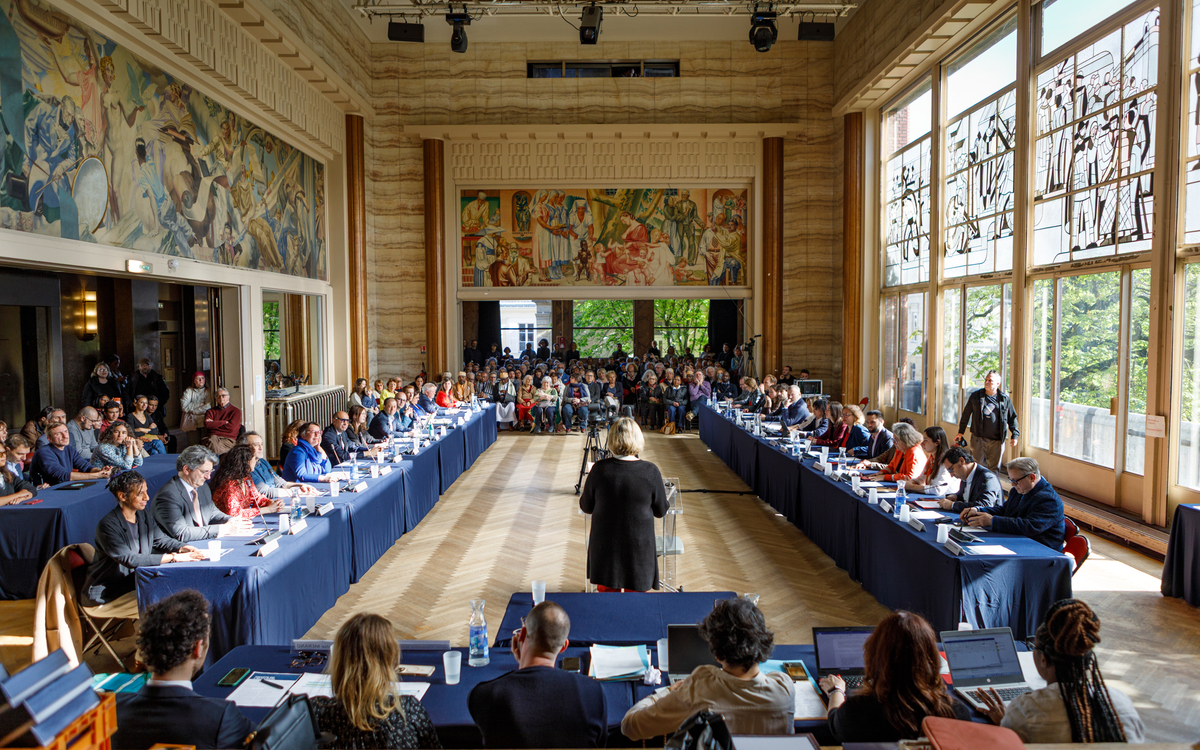 Vue panoramique sur la salles des fêtes de l'annexe de la mairie avec public et table du conseil présidente de la seance face à la salle de dos