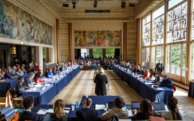 Vue panoramique sur la salles des fêtes de l'annexe de la mairie avec public et table du conseil présidente de la seance face à la salle de dos