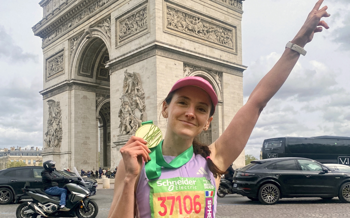 Alice, marathonienne, portant fièrement sa médaille. 