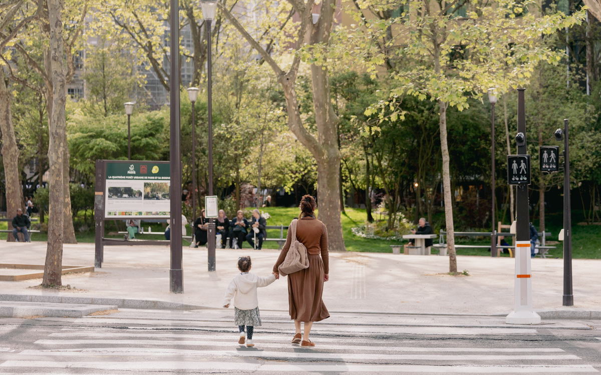 Une personne et un enfant traversent une route sur un passage piéton.