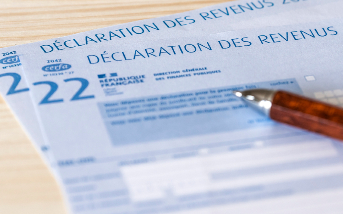 stylo posé sur des feuilles de déclaration des revenus, en gros plan