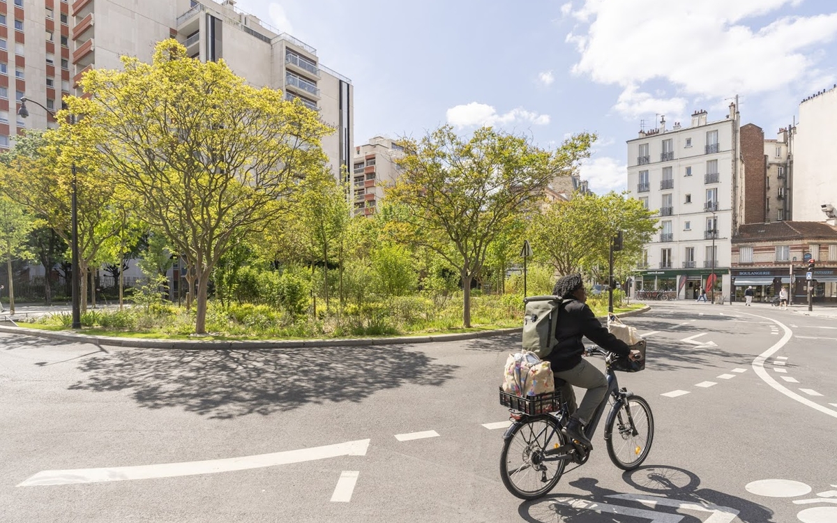 Photo de la végétalisation de la place de Rungis, avec un cycliste au premier plan