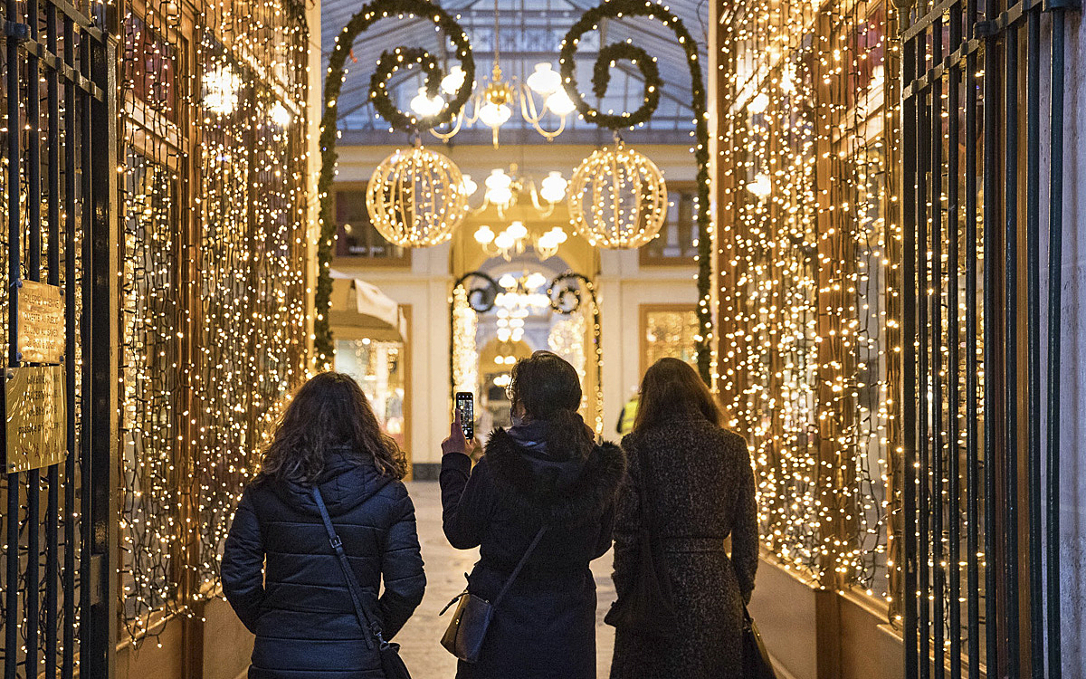 3 femmes entrent dans un passage illuminé pour les fêtes de fin d'année