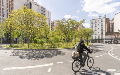 Photo de la végétalisation de la place de Rungis, avec un cycliste au premier plan