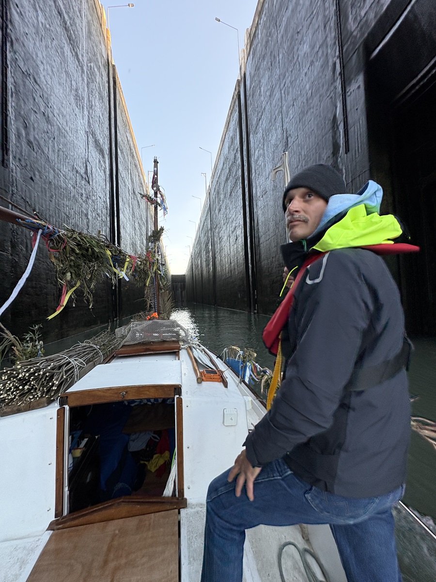 Un des deux hommes du duo Mr et Mr; est sur le bateau et passe une écluse