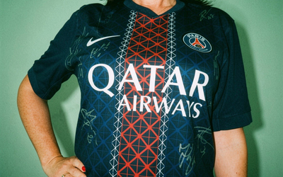 Une femme portant un maillot dédicacé du PSG. 