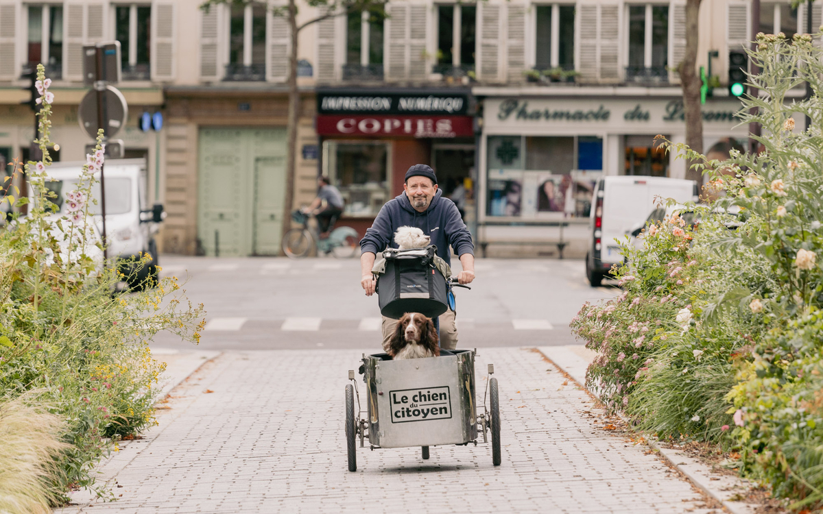 Alain Lambert sur son triporteur accompagné de ses deux chiens 