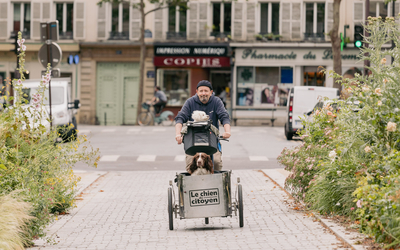 Alain Lambert sur son triporteur accompagné de ses deux chiens 