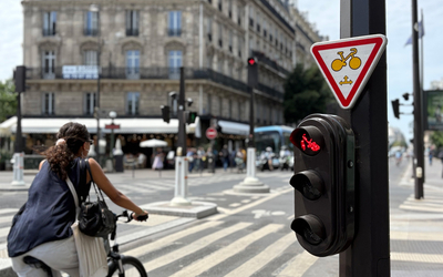 une cycliste passe devant un panneau M12 alors que le feu est rouge
