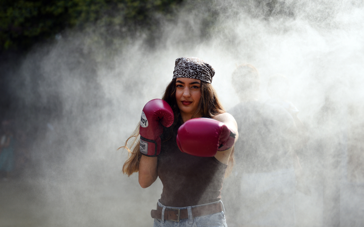 Portrait de Jeanne, championne du monde de muay thai, à travers la brume des brumisateurs du square Maurice Gardette.